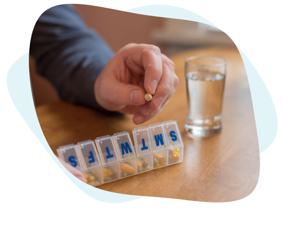 Person put pills into a pillbox.